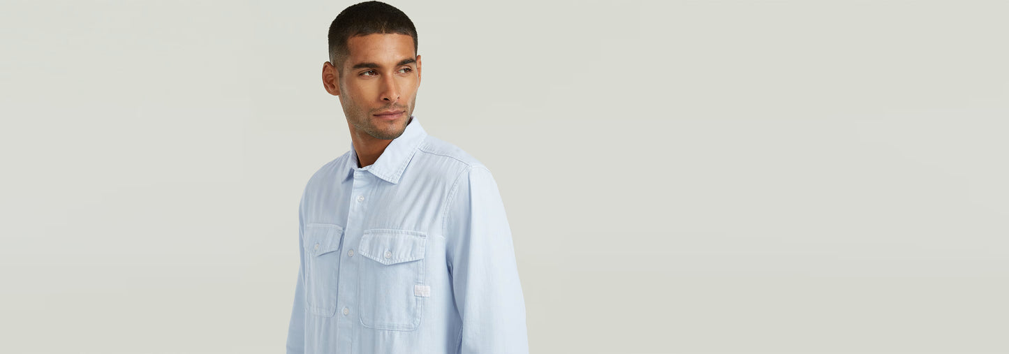 Hombre modelando la Camisa Marine Slim de corte ajustado y bajos redondeados, con bolsillos en el pecho.