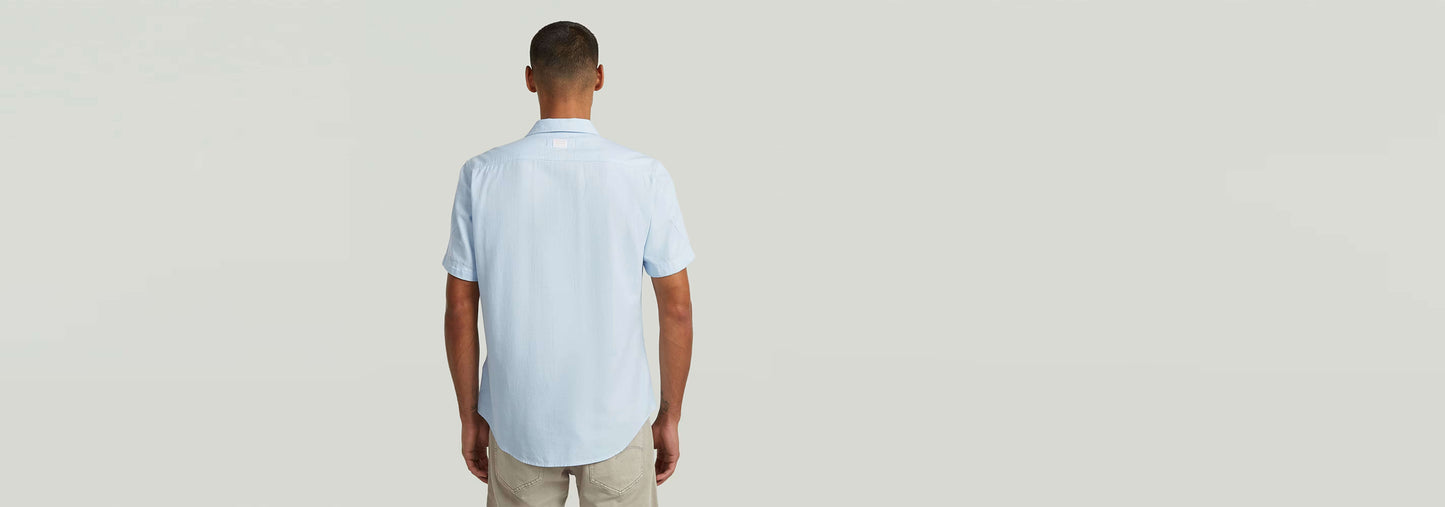 Vista trasera de un hombre usando la Camisa Marine Slim de corte ajustado y bajo redondeado.