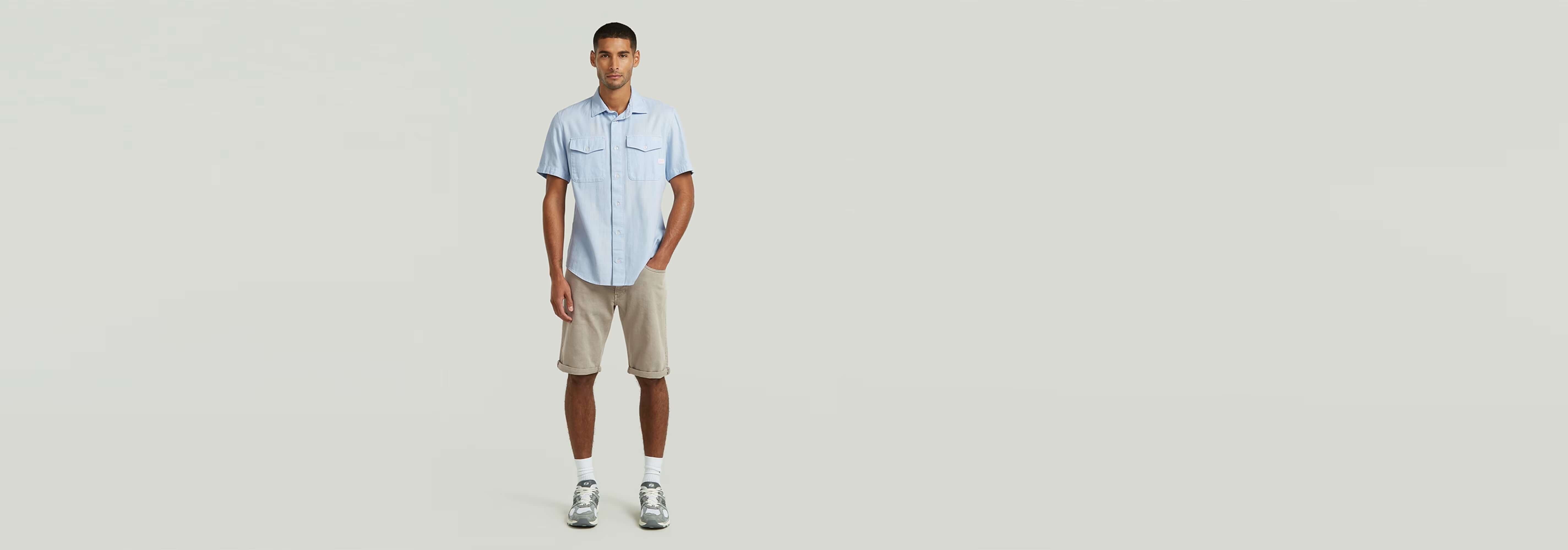 Hombre vistiendo la Camisa Marine Slim con pantalones cortos en un fondo minimalista.