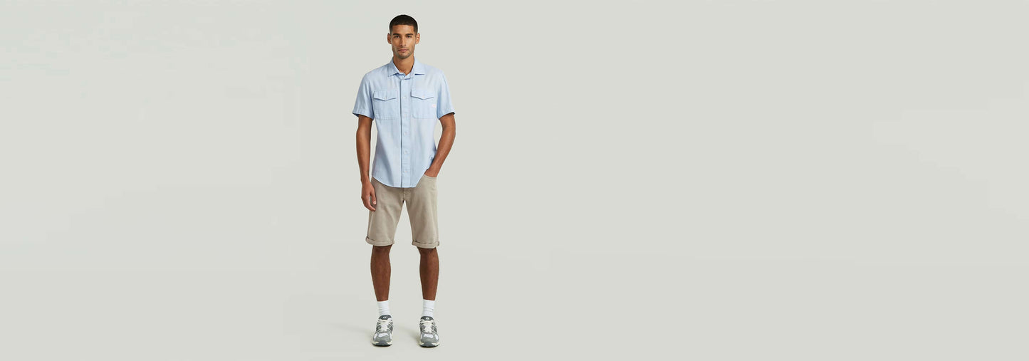 Hombre vistiendo la Camisa Marine Slim con pantalones cortos en un fondo minimalista.