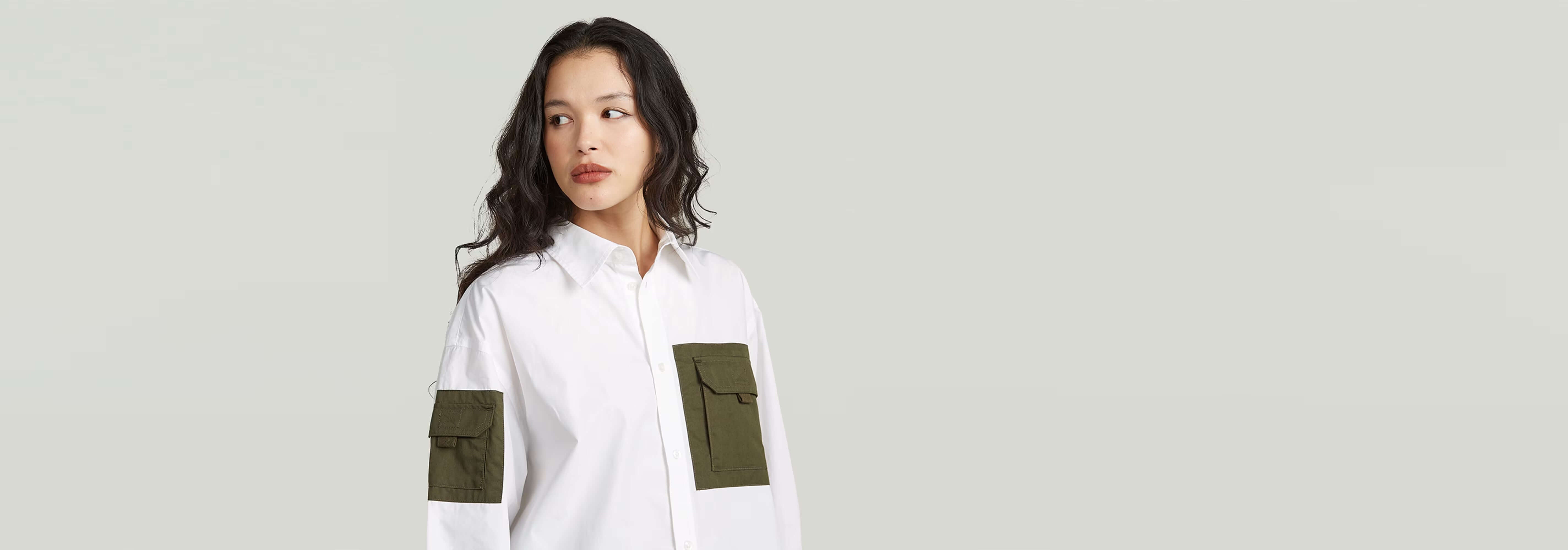 Modelo vistiendo una Camisa Multipocket de manga larga con bolsillos de parche en color blanco y verde.