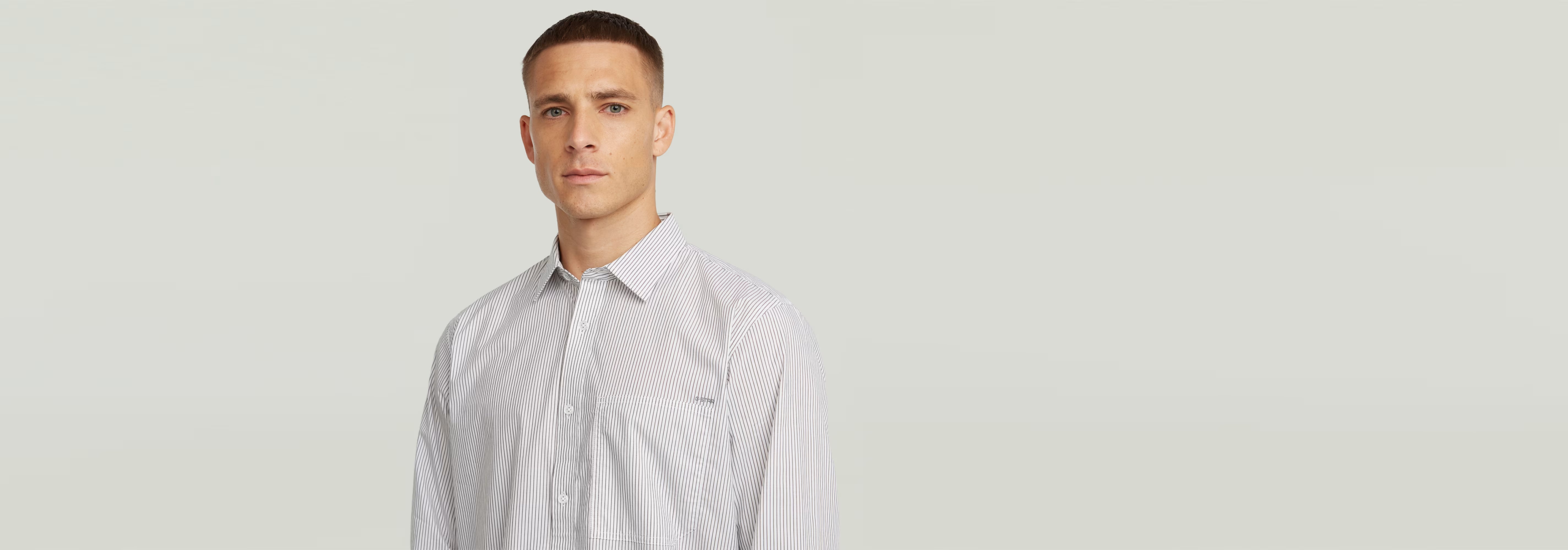 Hombre usando la Camisa One Pocket Regular de manga larga con diseño de rayas y cuello clásico.