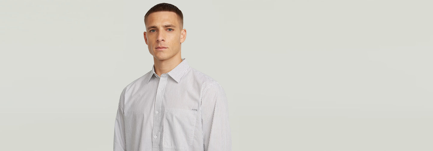 Hombre usando la Camisa One Pocket Regular de manga larga con diseño de rayas y cuello clásico.