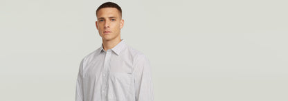Hombre usando la Camisa One Pocket Regular de manga larga con diseño de rayas y cuello clásico.