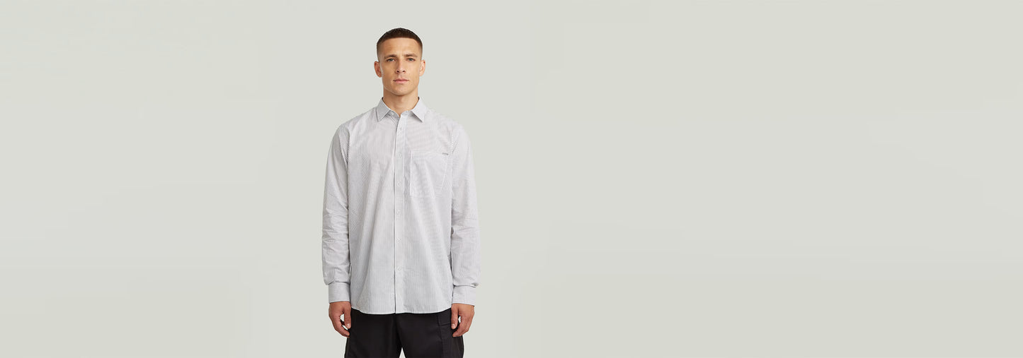 Modelo vistiendo la Camisa One Pocket Regular de manga larga con cierre de botones y un bolsillo en el pecho.