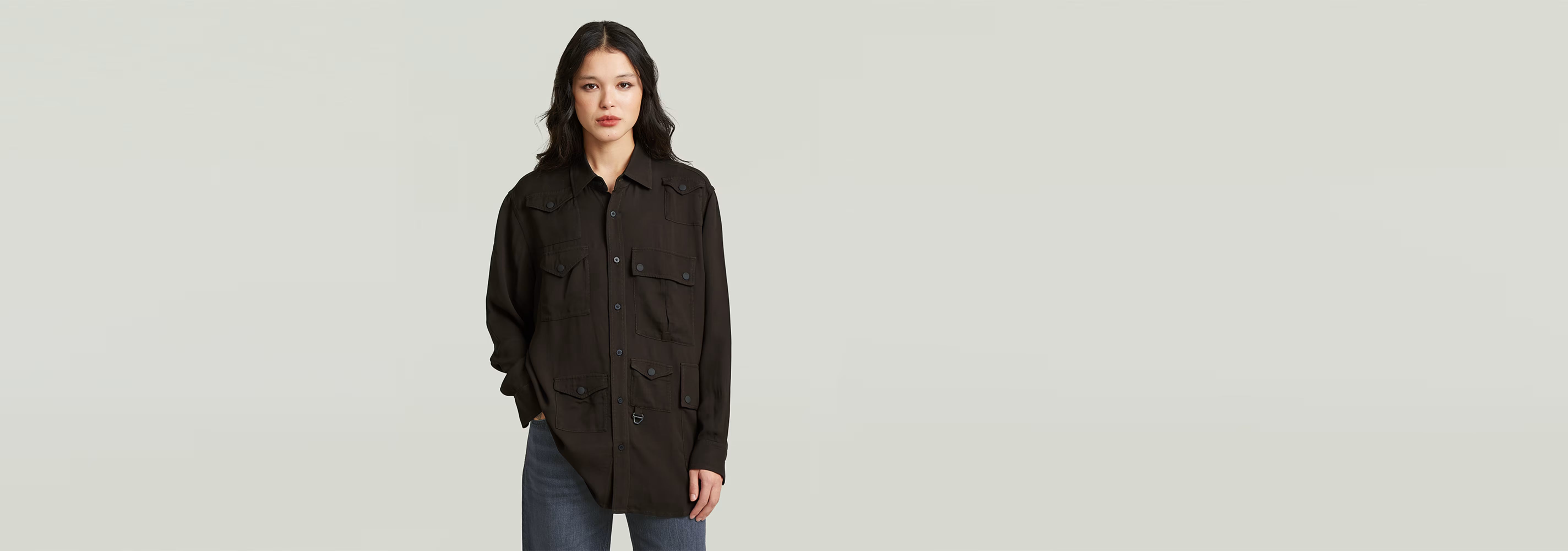 Camisa Relaxed Pocket en color negro, con cierre de botones y diseño informal, ideal para un look versátil.