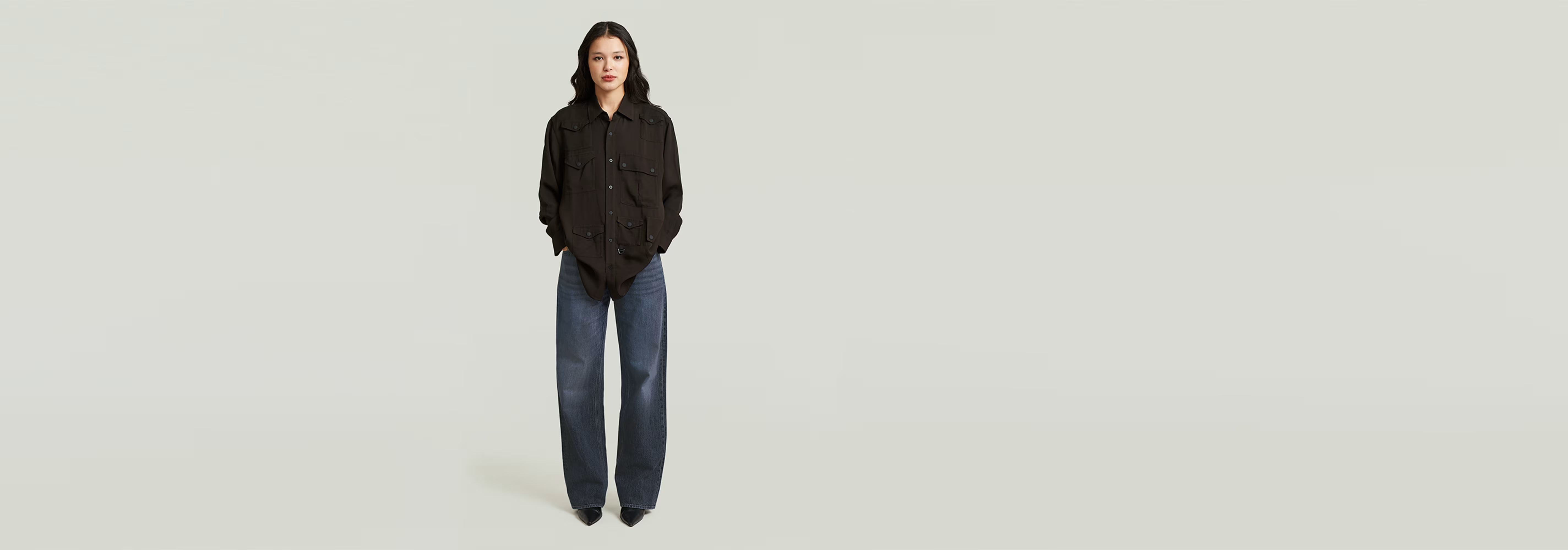 Mujer usando la Camisa Relaxed Pocket con pantalones anchos, diseño informal y cortes relajados.