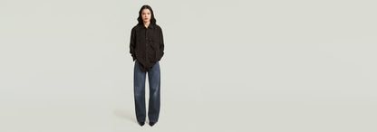 Mujer usando la Camisa Relaxed Pocket con pantalones anchos, diseño informal y cortes relajados.