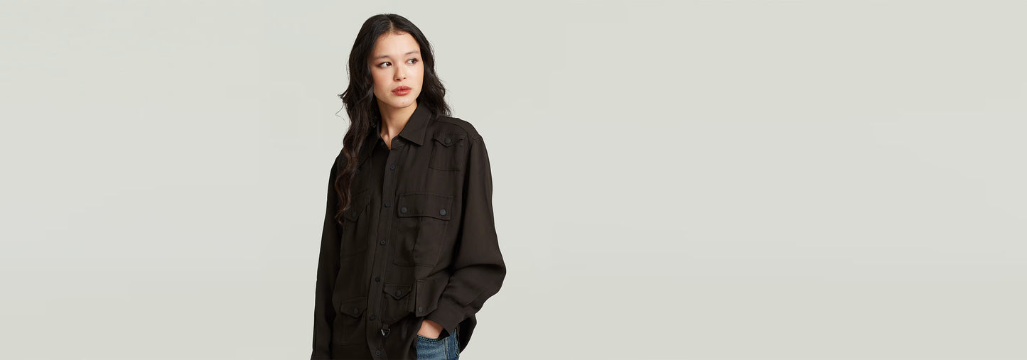 Mujer luciendo una camisa Relaxed Pocket en color negro, con diseño informal y múltiples bolsillos.