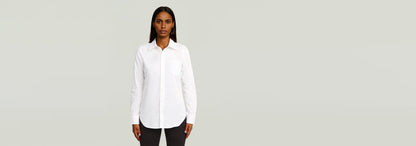Camisa Slim Poplin Long Sleeve de manga larga, con cierre de botones y cuello de camisa en color blanco.