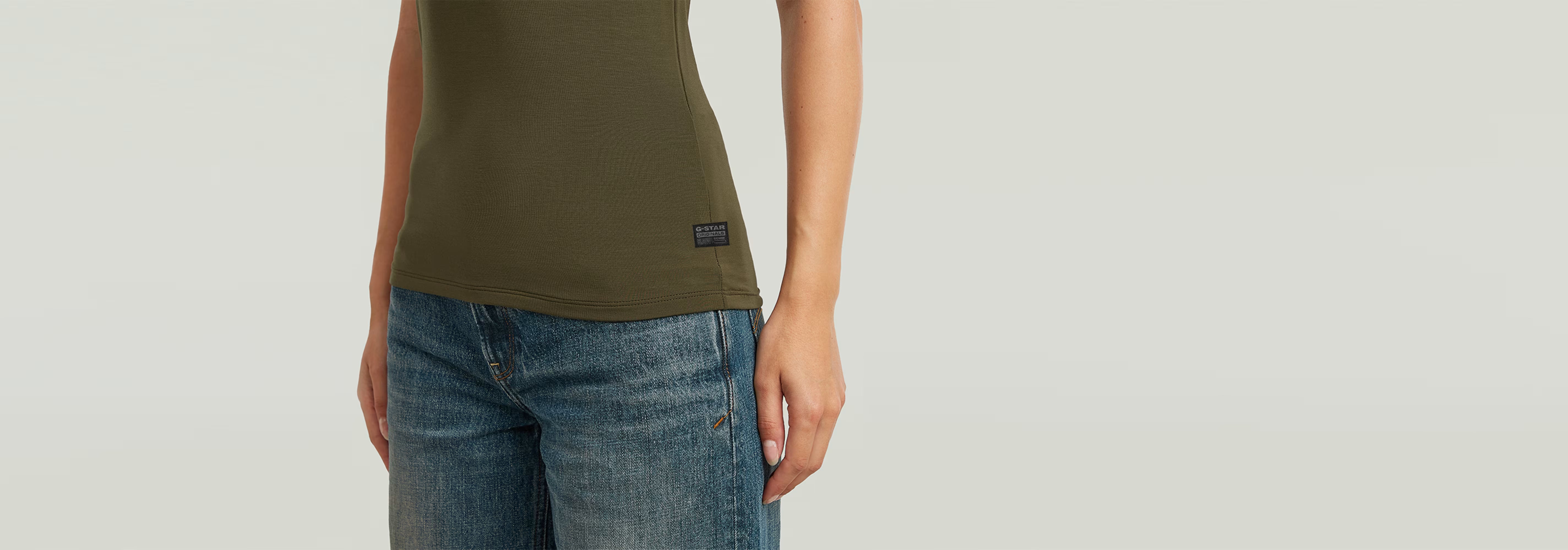 Mujer usando la camiseta 2nd Skin Mock de corte ajustado y cuello de tortuga, combinada con jeans.
