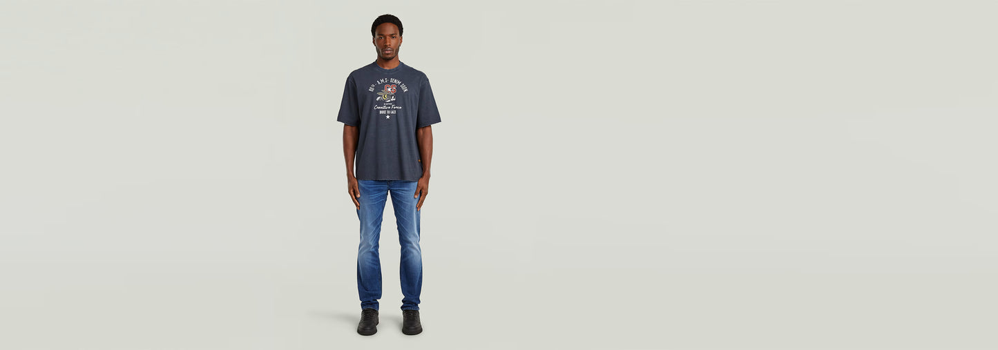 Modelo vistiendo la Camiseta Angry Bee Loose con diseño gráfico frente y jeans, fondo claro.