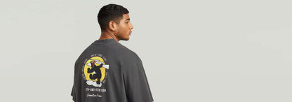Hombre usando la camiseta Back Graphic Loose con estampado gráfico en la parte posterior y corte suelto.