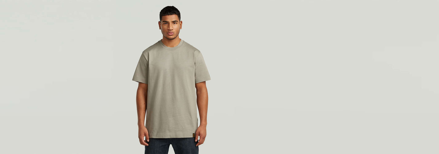 Hombre modelando la Camiseta GS-01 de corte regular, color gris claro, 100% algodón ecológico.