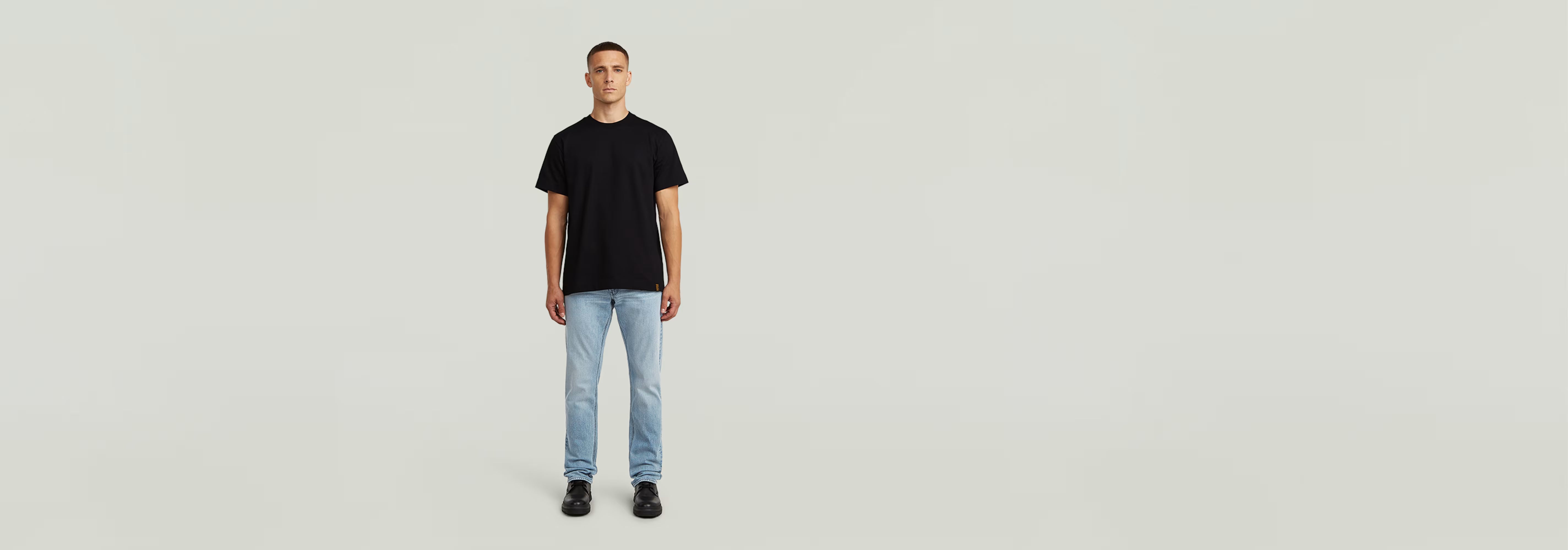 Modelo vistiendo la Camiseta GS-01 de color negro con jeans claros, en un fondo neutro.