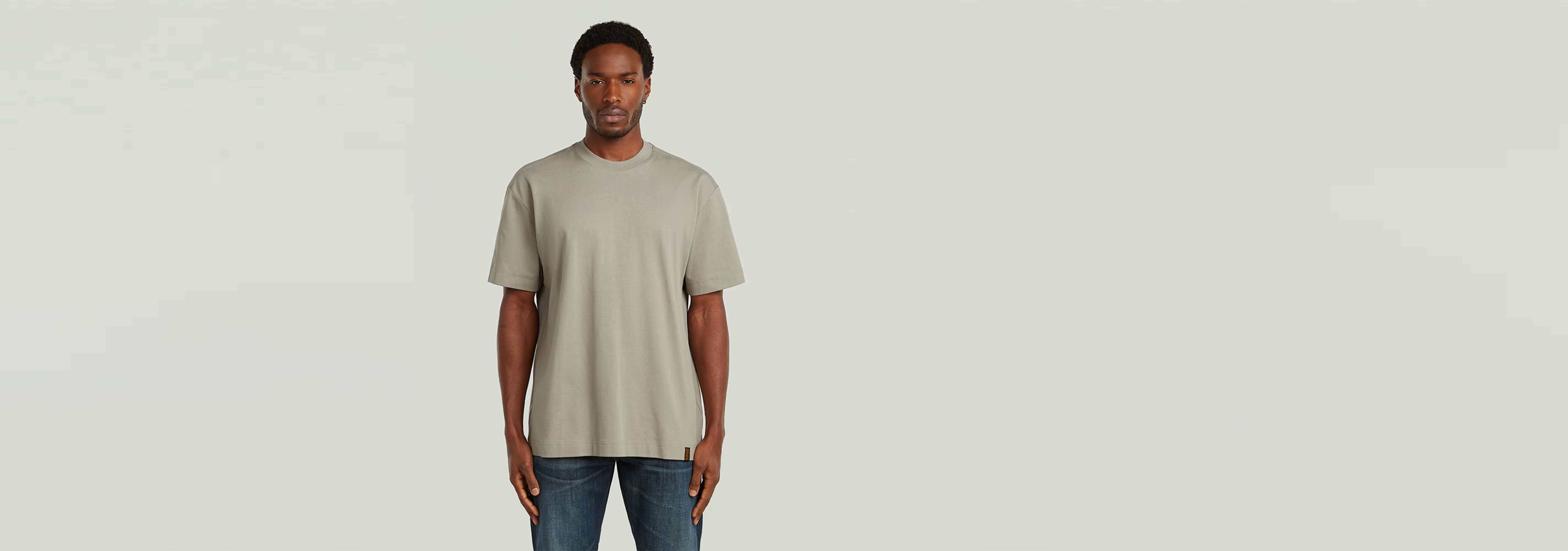 Modelo vistiendo la Camiseta GS-01 Relaxed en color beige, con corte relajado y cuello redondo.
