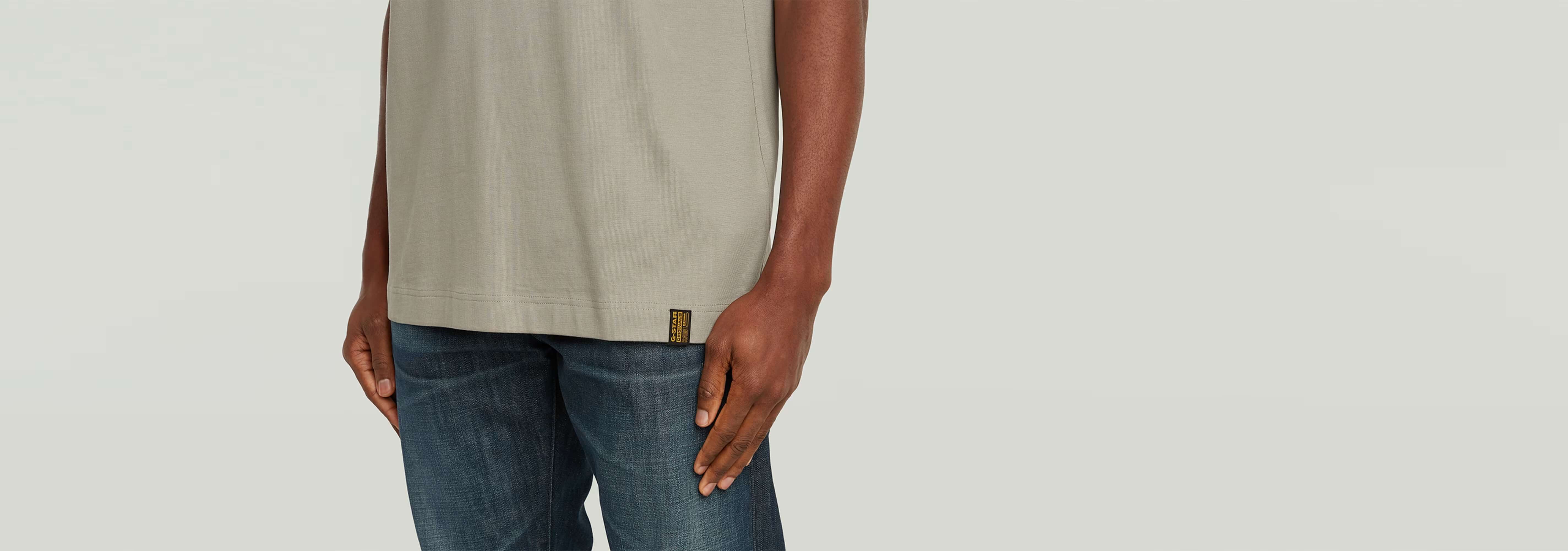 Camiseta GS-01 Relaxed mostrando corte relajado y detalle en la parte inferior, con jeans azul claro.