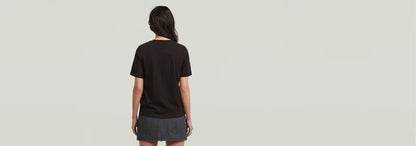 Mujer vista trasera usando la camiseta HD Graphic de corte recto y cuello redondo en color negro.