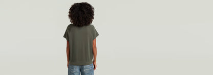 Mujer con camiseta Raglan de corte recto y mangas de casquillo, vista posterior, color verde.