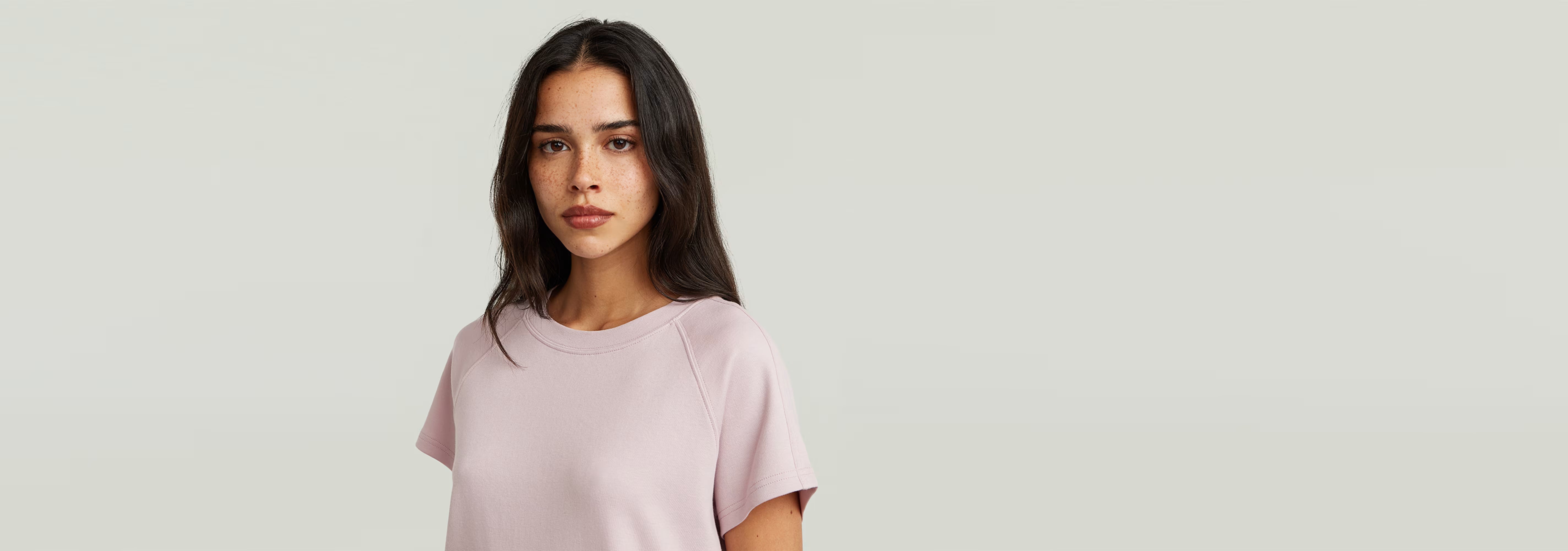 Camiseta Raglan de corte recto y mangas de casquillo en color rosa claro, confeccionada en 100% algodón ecológico.