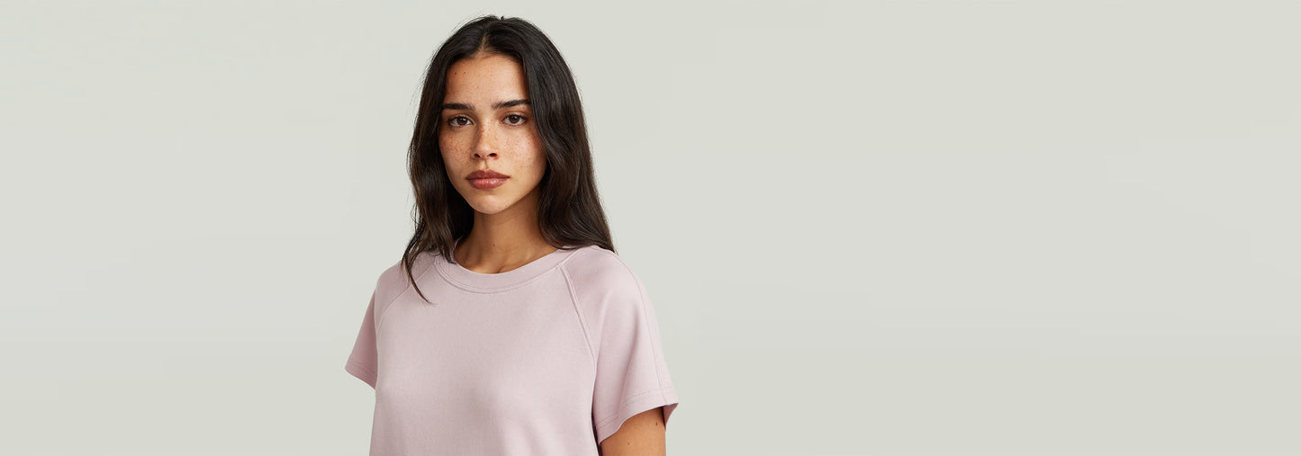Camiseta Raglan de corte recto y mangas de casquillo en color rosa claro, confeccionada en 100% algodón ecológico.
