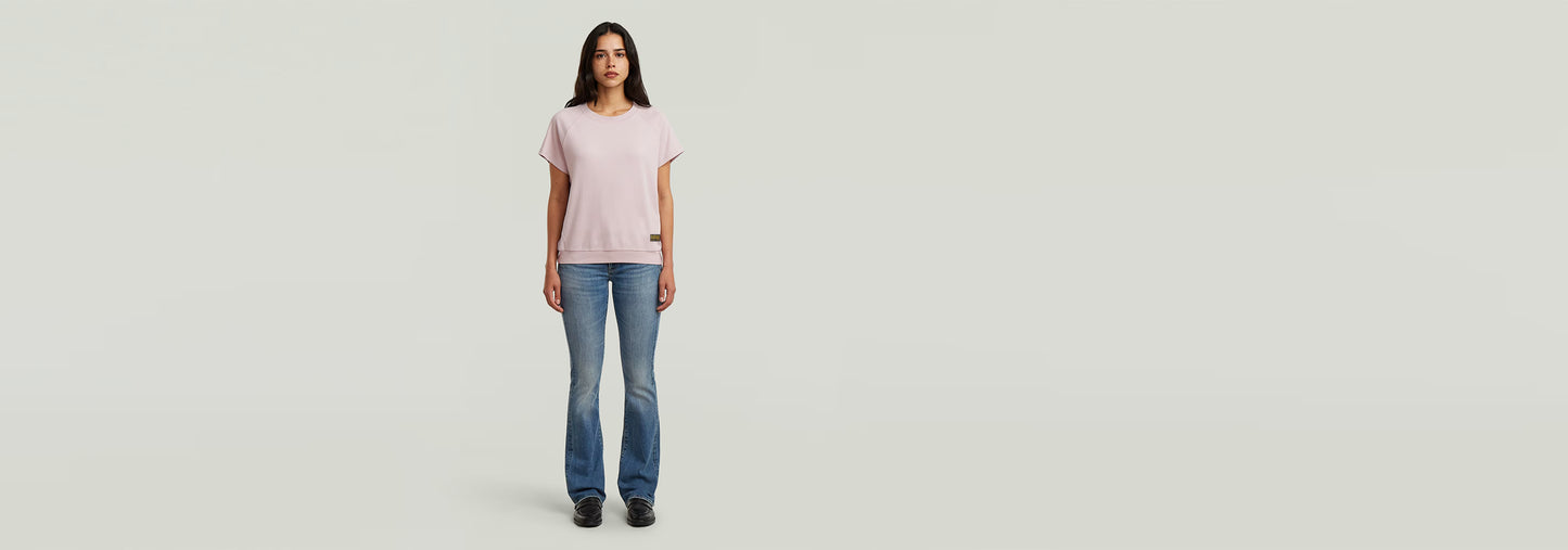 Camiseta Raglan de color rosa, con corte recto, mangas de casquillo y cuello redondo, combinada con jeans.