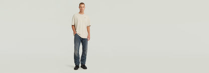 Modelo vistiendo la Camiseta Rib Insert Relaxed con jeans y calzado deportivo en un fondo neutro.