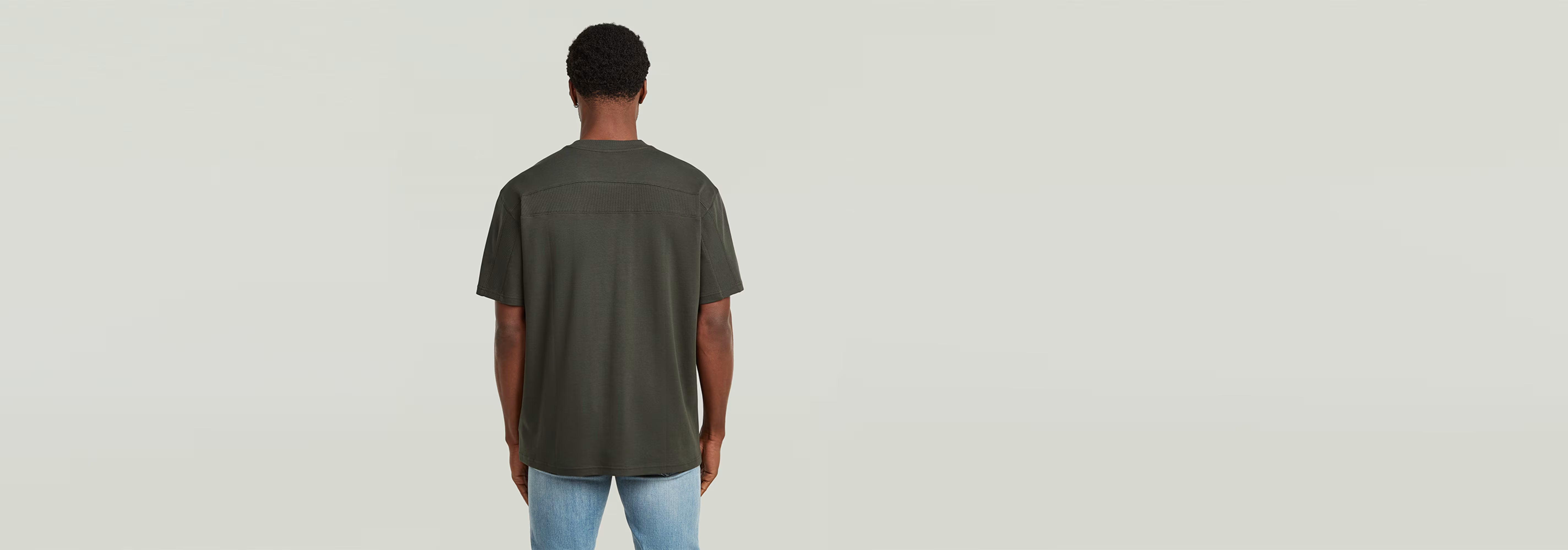 Hombre vista trasera usando la camiseta Rib Insert Relaxed de color verde, con diseño casual y cómodo.
