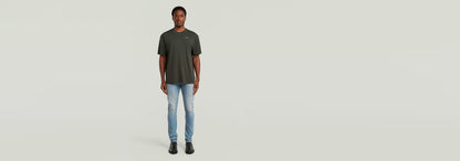 Modelo usando la Camiseta Rib Insert Relaxed en color verde, combinada con jeans claros, fondo neutro.