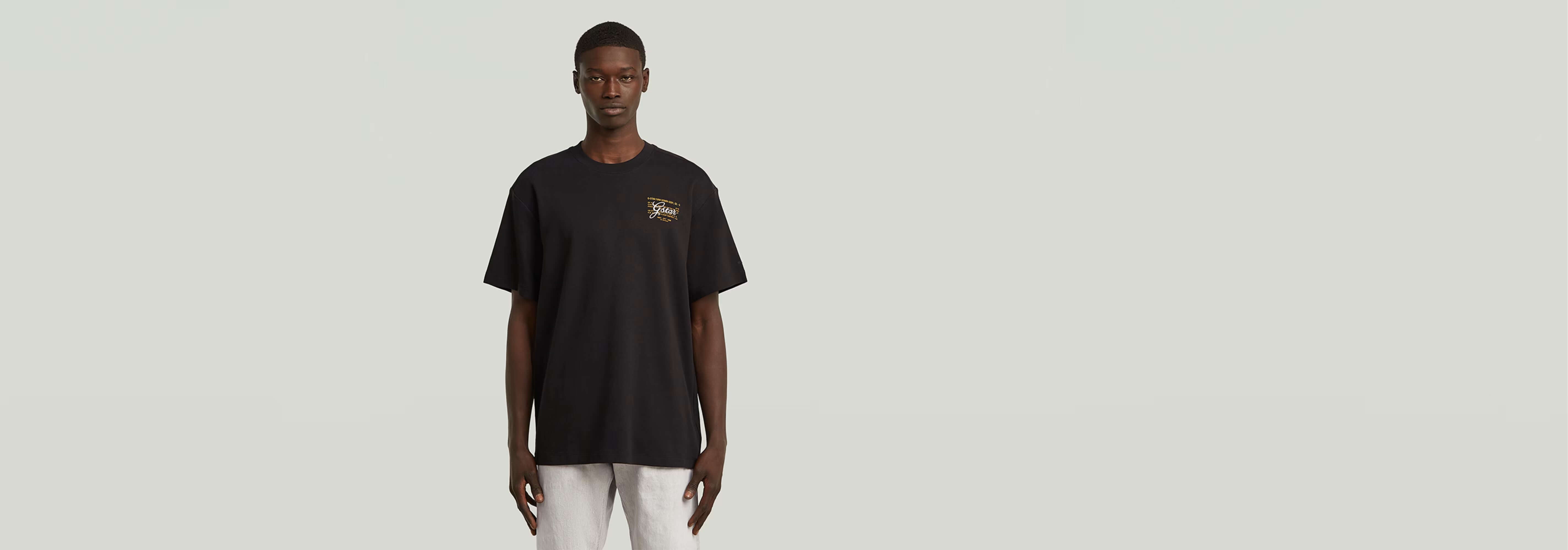 Camiseta Script de algodón orgánico, cuello redondo y diseño gráfico, modelo masculino en fondo neutro.