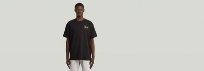 Camiseta Script de algodón orgánico, cuello redondo y diseño gráfico, modelo masculino en fondo neutro.