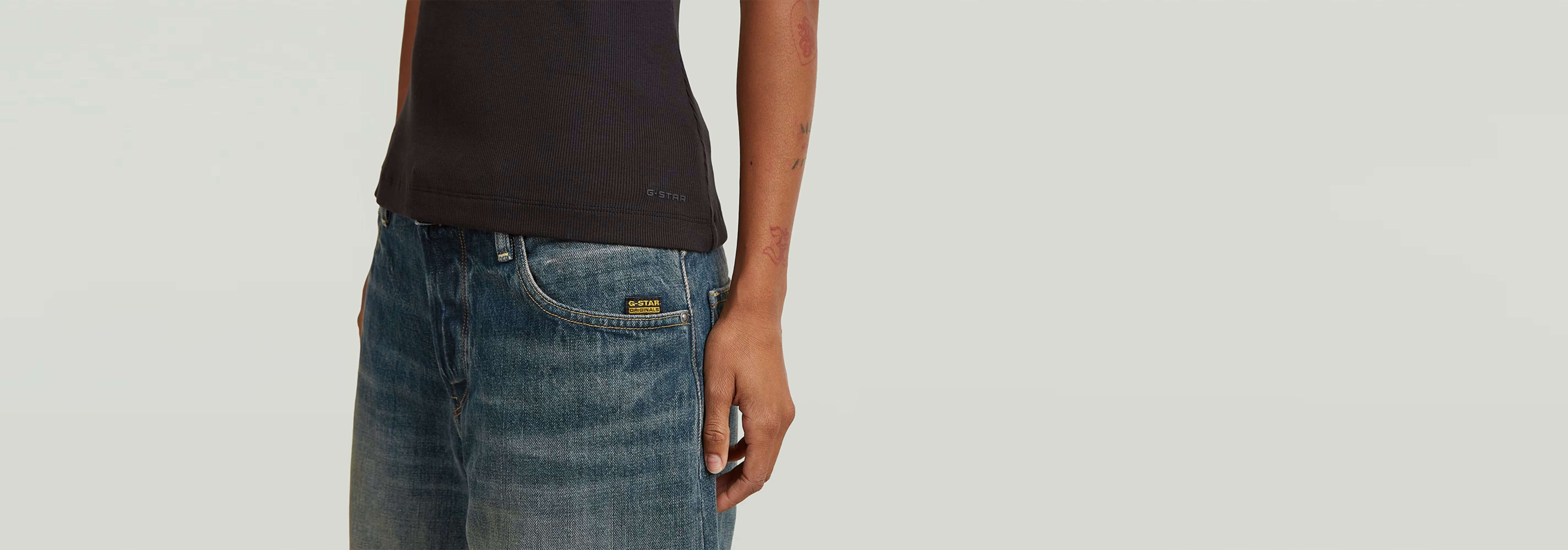Camiseta Slim Rib en color negro, con diseño de cuello redondo y combinada con jeans azules, mostrando un look versátil.