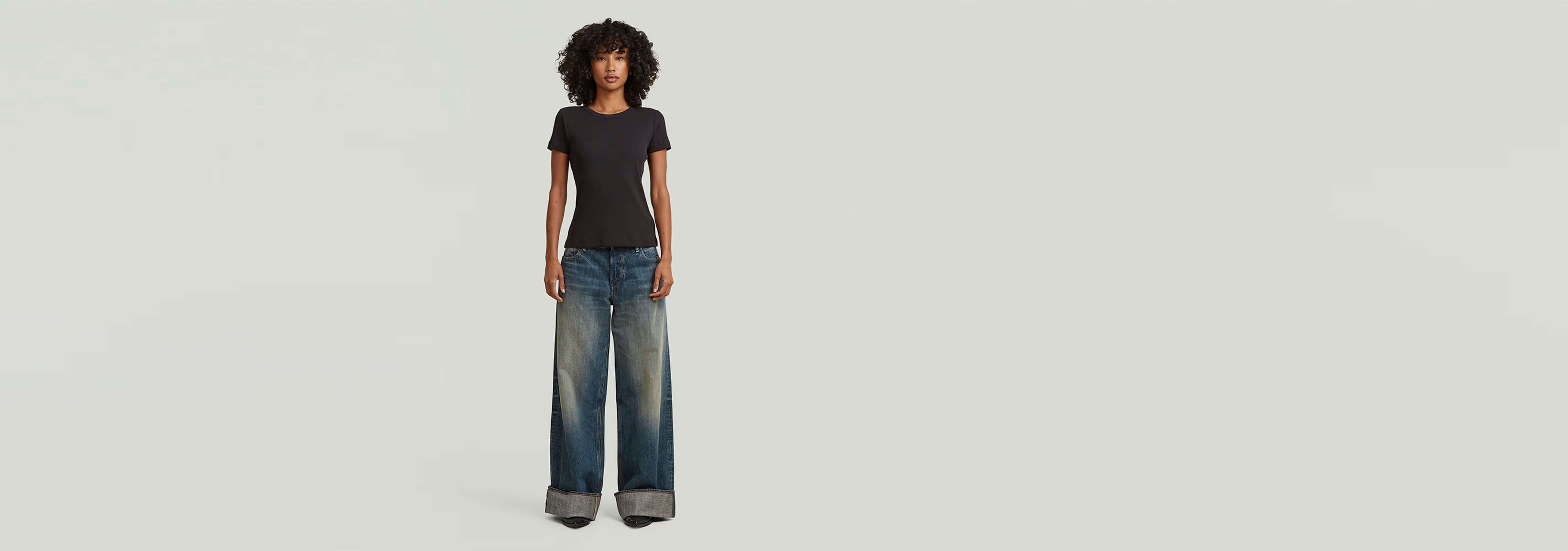 Camiseta Slim Rib modelo con jeans anchos, presentando un look atractivo y moderno.