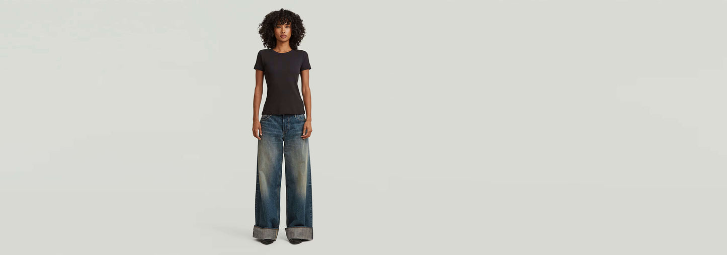 Camiseta Slim Rib modelo con jeans anchos, presentando un look atractivo y moderno.