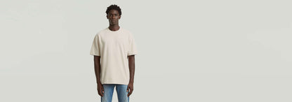 Hombre vistiendo la Camiseta Structured Relaxed Base de diseño gráfico en color claro, con un estilo moderno y relajado.