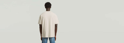 Hombre vistiendo la Camiseta Structured Relaxed Base desde atrás, mostrando su corte relajado y estilo moderno.