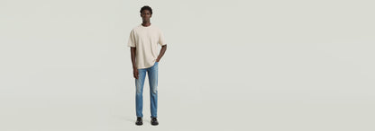 Hombre vistiendo una camiseta Structured Relaxed Base de corte relajado y jeans, mostrando un estilo moderno.