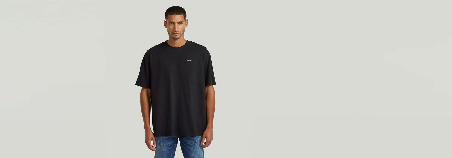 Camiseta Structured Relaxed Base en color negro, con corte relajado y cuello redondo, ideal para un look moderno.
