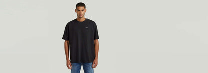 Camiseta Structured Relaxed Base en color negro, con corte relajado y cuello redondo, ideal para un look moderno.