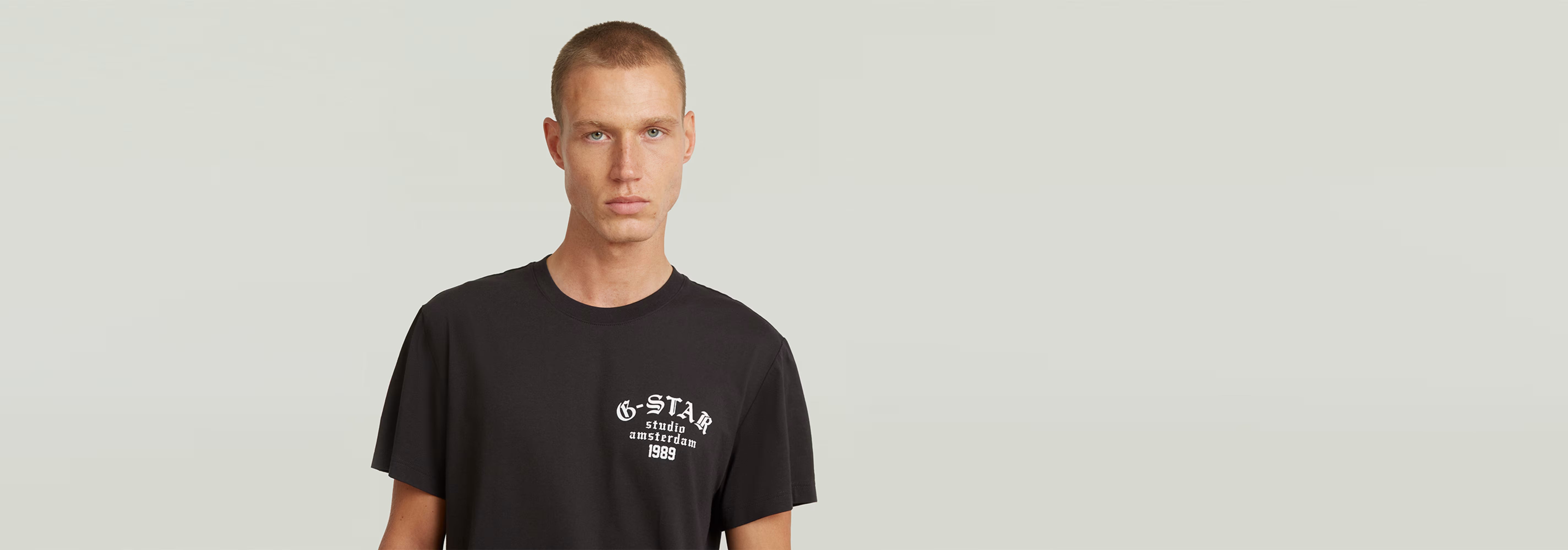 Hombre usando la Camiseta Studio AMS negra con estampado gráfico en el pecho y cuello redondo.
