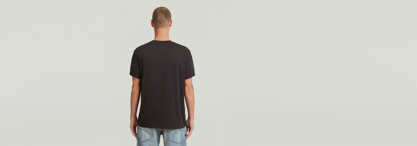 Camiseta Studio AMS negra vista posterior en modelo masculino, diseño clásico y cómodo de algodón ecológico.