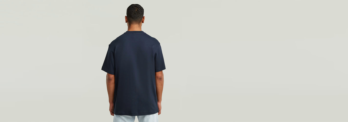 Hombre vistiendo la camiseta True Regular de color oscuro, vista trasera que muestra el diseño clásico.