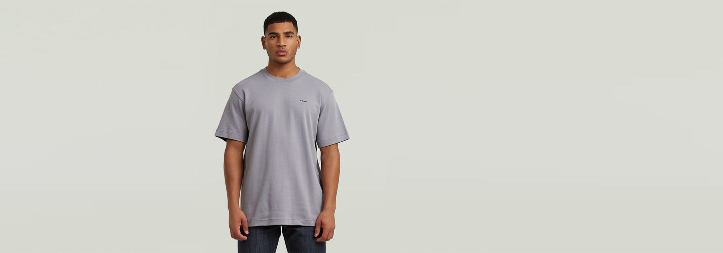 Modelo masculino usando una camiseta True Regular de color gris, con cuello redondo y ajuste regular.