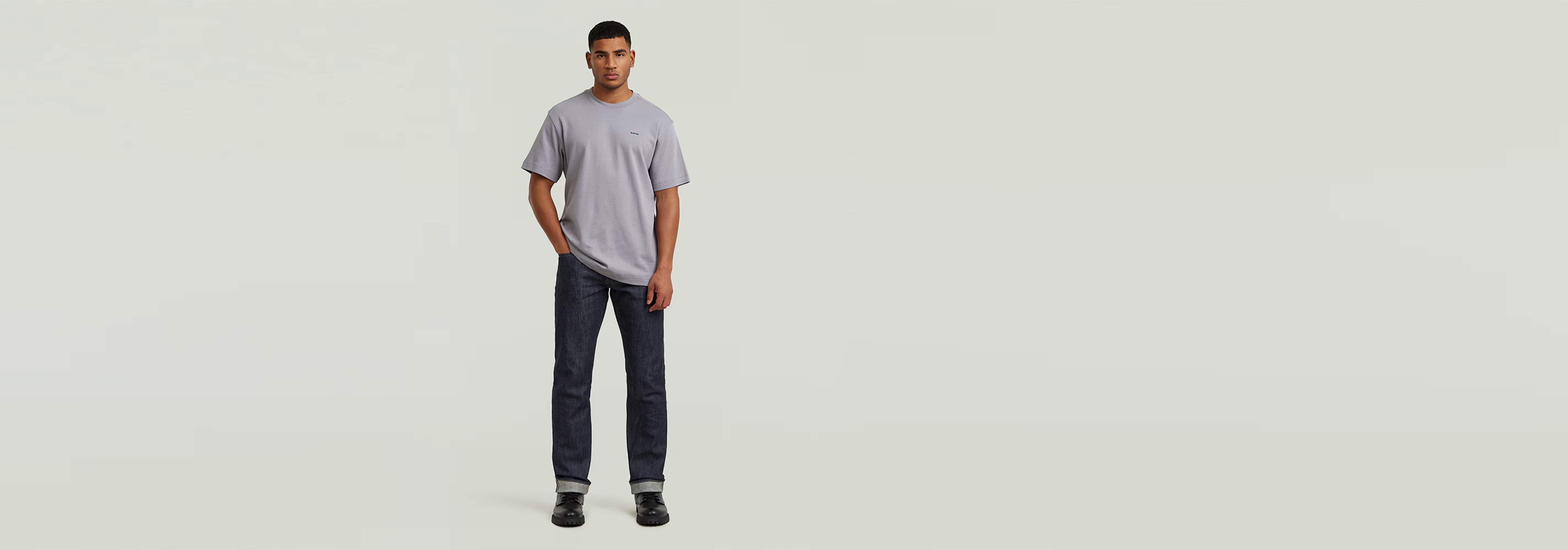 Modelo usando la Camiseta True Regular en color gris, con jeans oscuros y una postura casual.