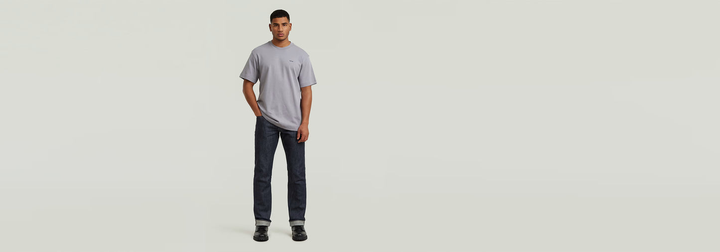 Modelo usando la Camiseta True Regular en color gris, con jeans oscuros y una postura casual.