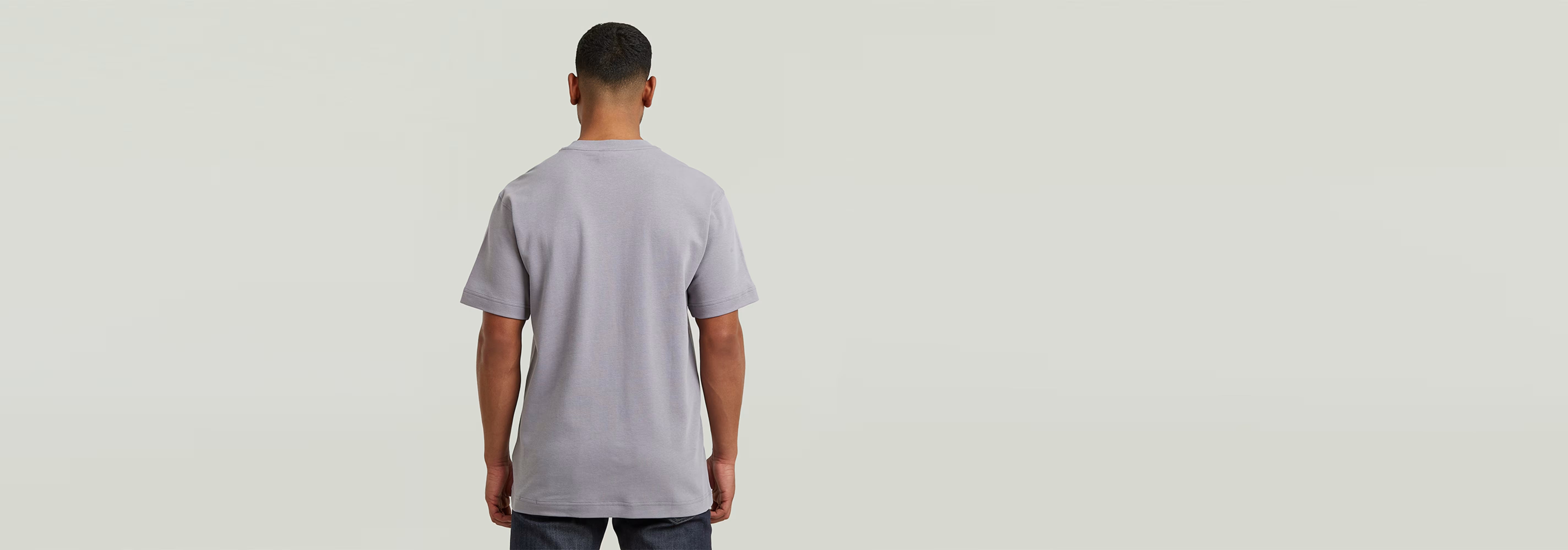 Hombre de espaldas vistiendo la Camiseta True Regular en color gris con ajuste cómodo.