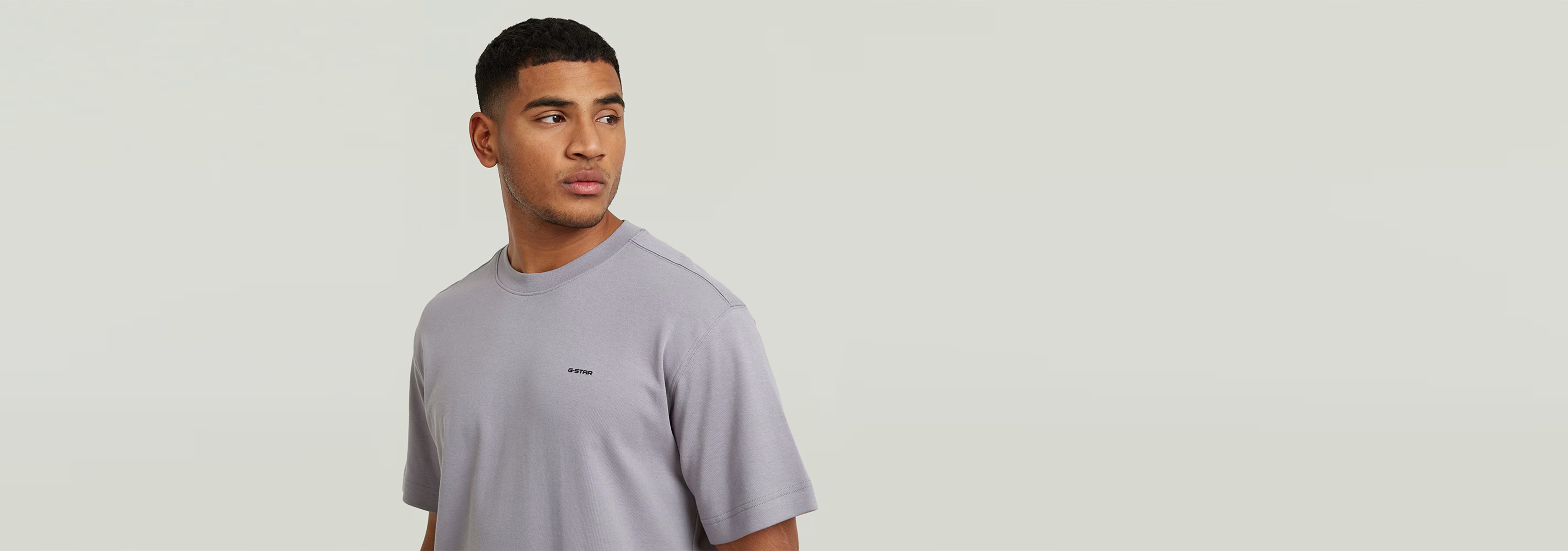 Modelo usando la Camiseta True Regular en color gris con cuello redondo y manga corta.