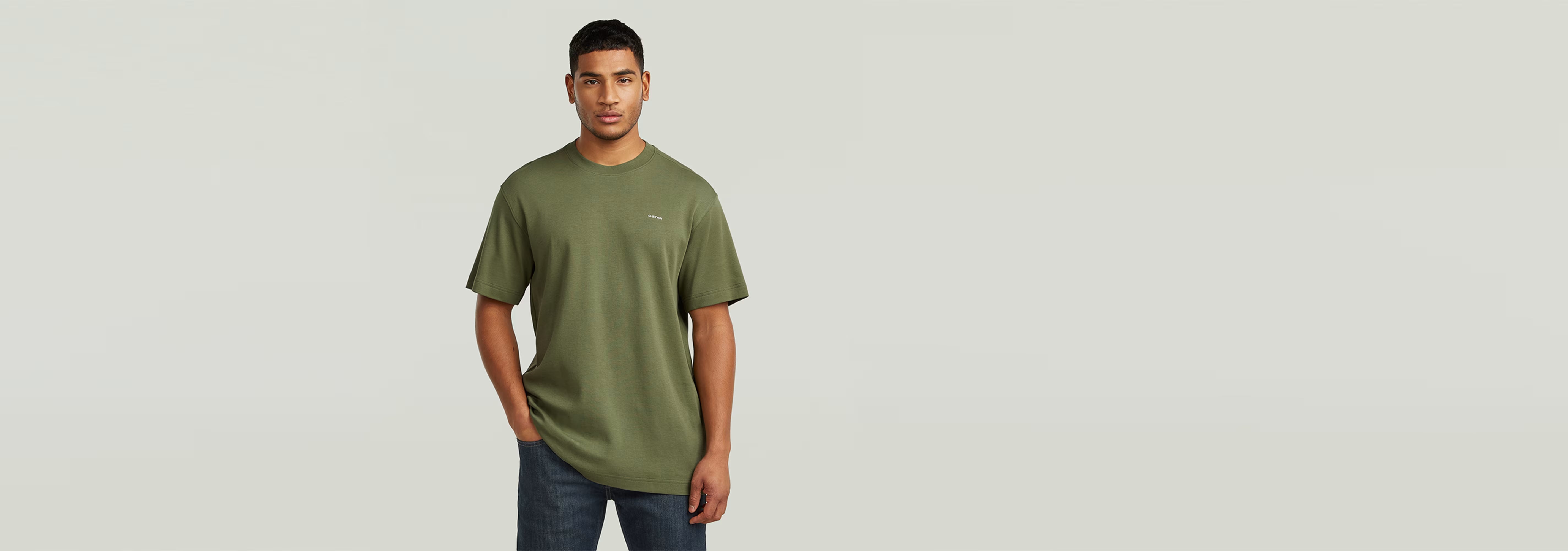 Modelo vistiendo la Camiseta True Regular en color verde oliva, con ajuste clásico y estampado gráfico.