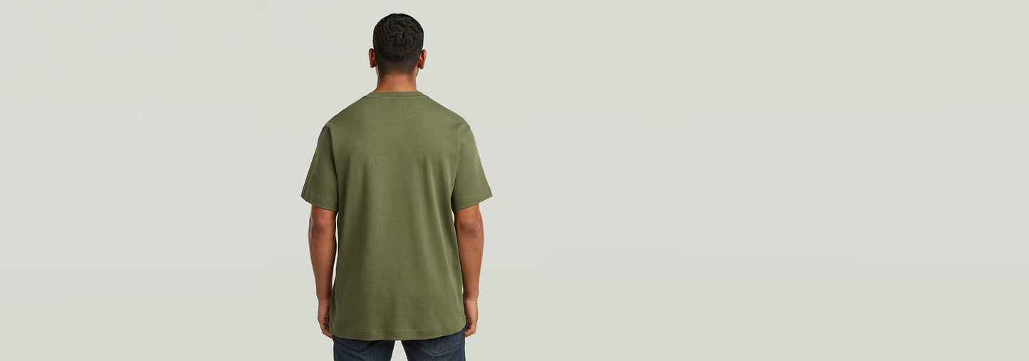 Hombre de espaldas usando la camiseta True Regular de color verde, con cuello redondo y ajuste regular.