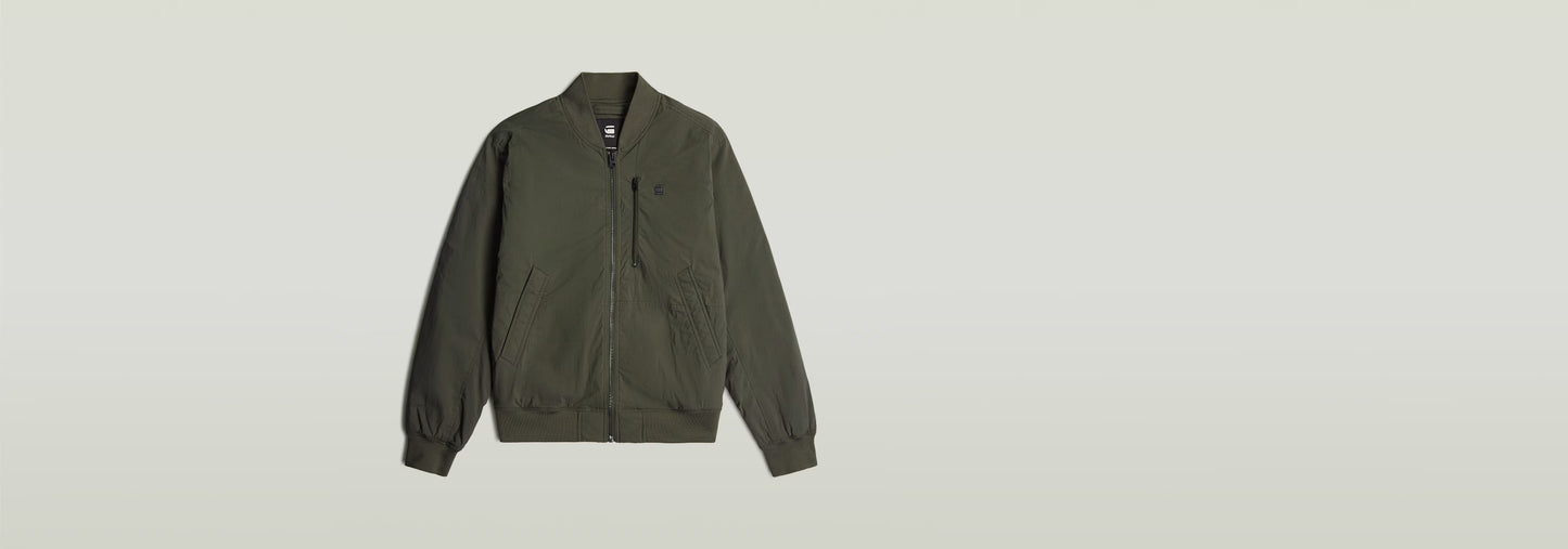 Cazadora de aviador Tech en color verde, diseño acolchado con cierre de cremallera y cuello de canalé.